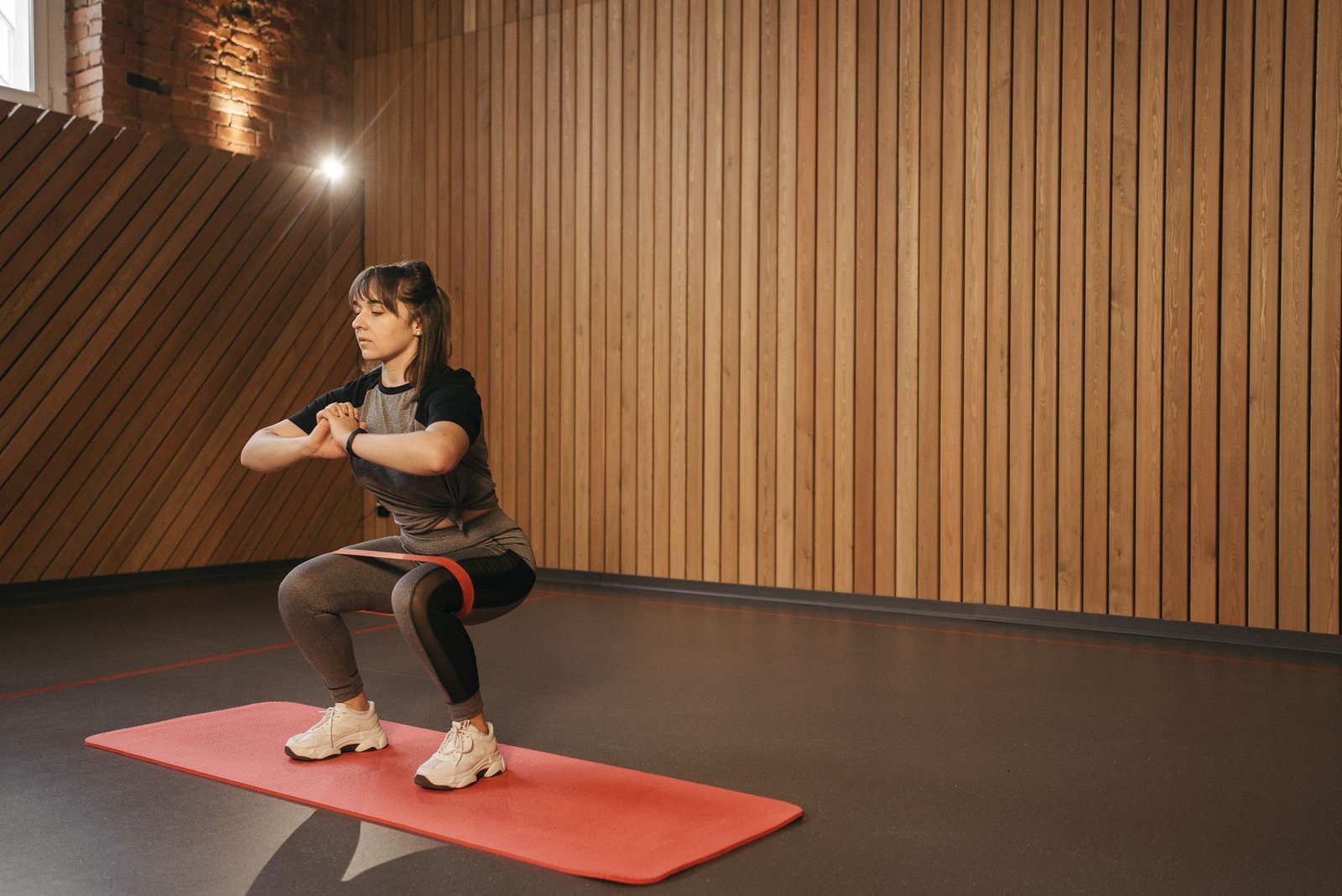 Jonge vrouw traint met een weerstandsband op een yogamat